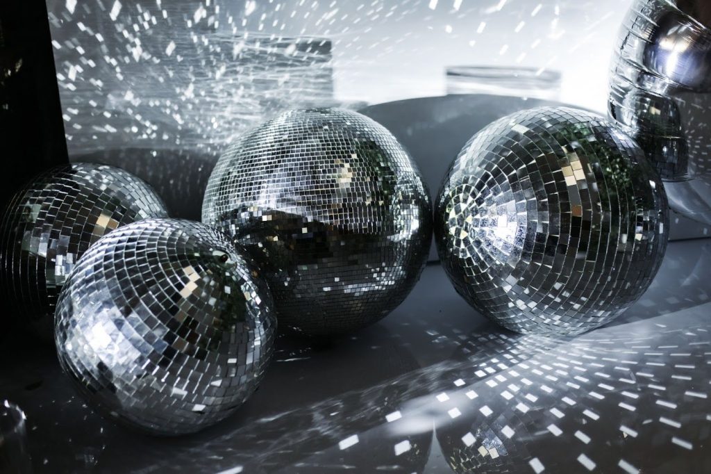 Cuatro bolas de discoteca en una pista de baile gris